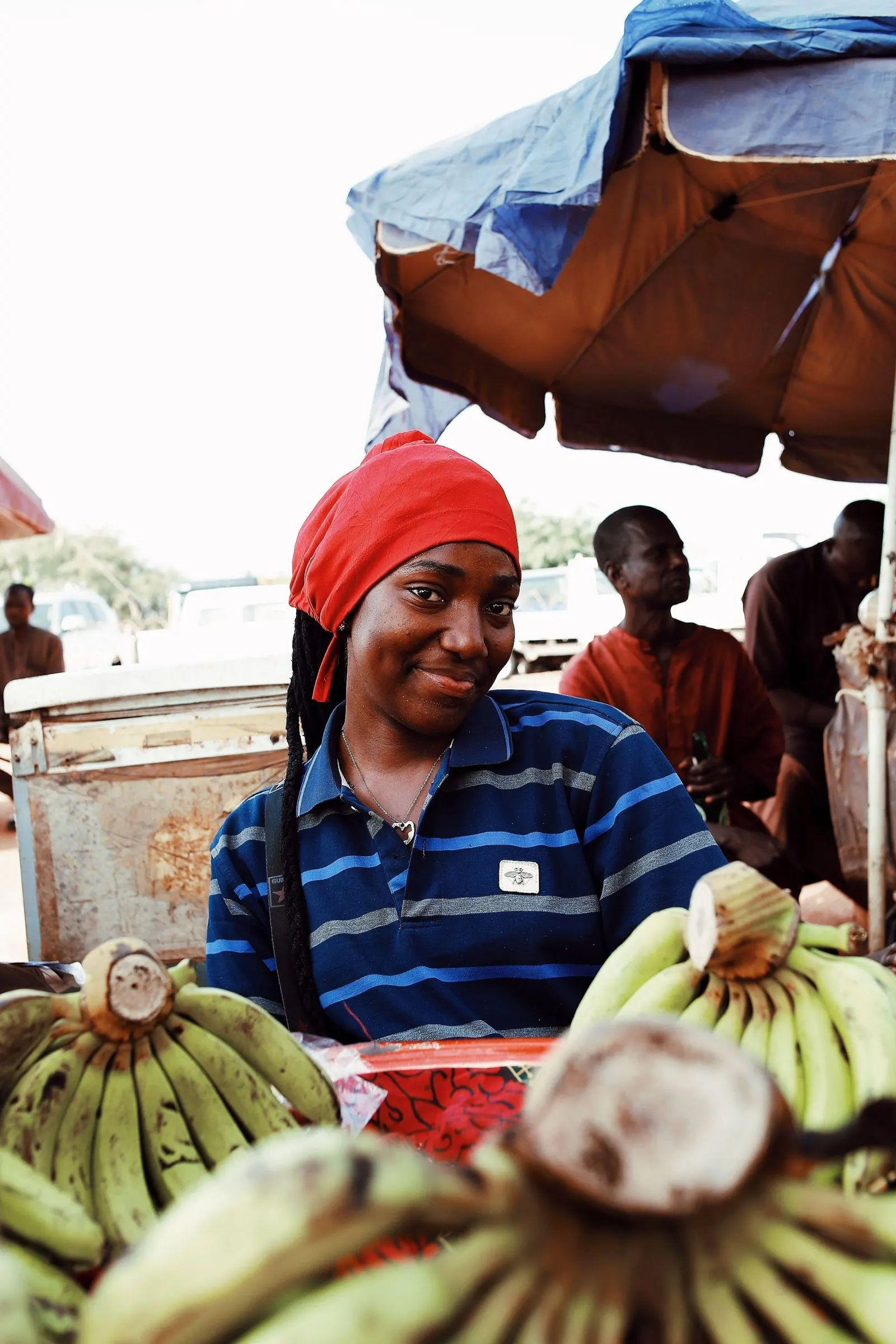 A banana seller in Abuja smiles over the bunches on her stall