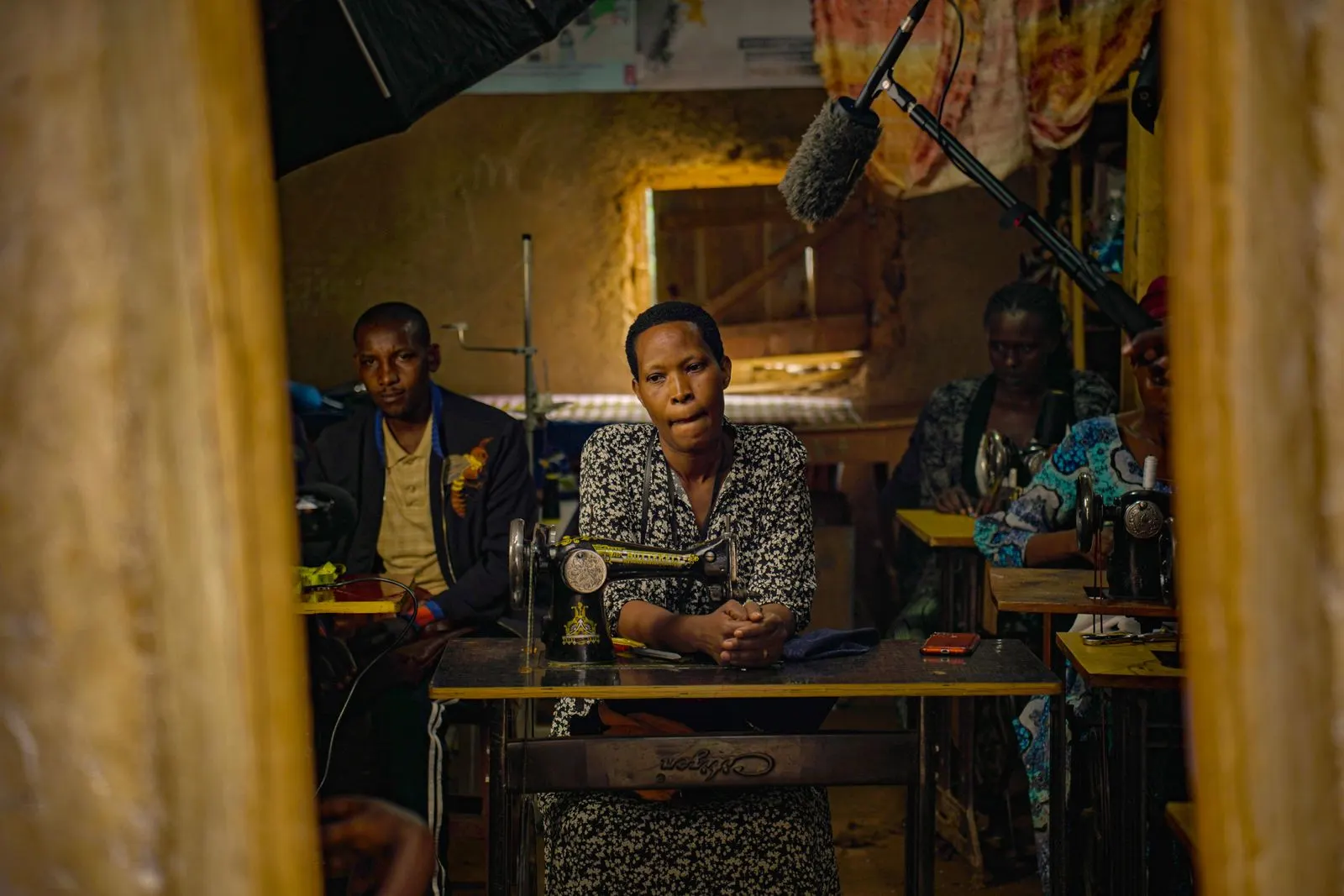 Tailors at their sewing machines in a small workshop